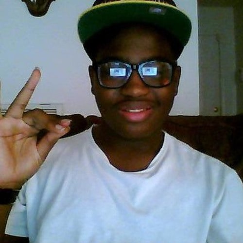 Wooh da kid posing for the photo wearing spectacles and white t-shirt and showing his two fingers up